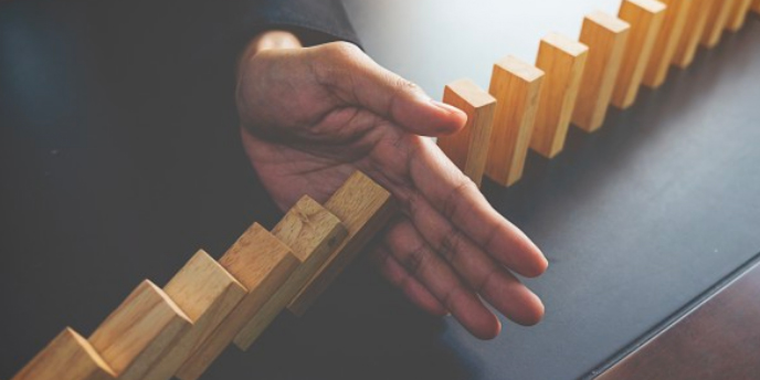 hand preventing the blocks from falling