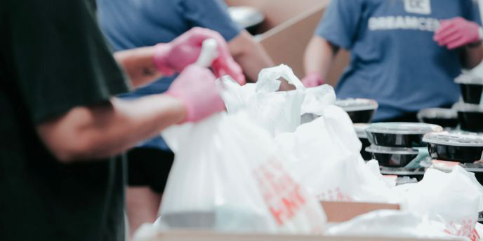 man putting food containers in a bag