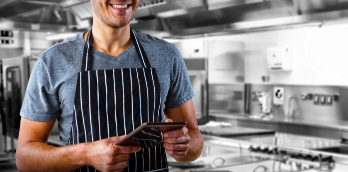 cook in a kitchen using a tablet