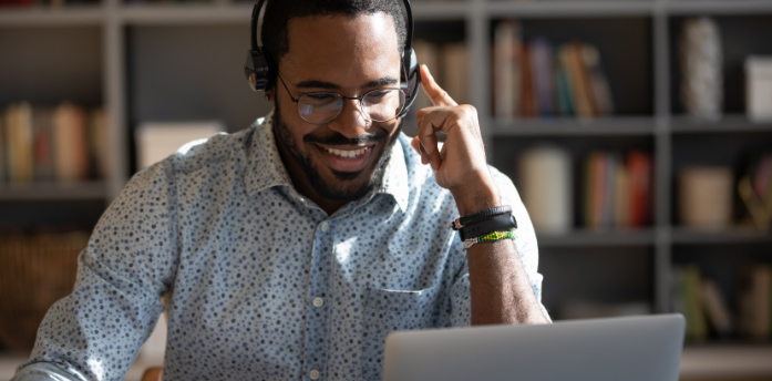 man sitting at desk wear headset watching webinar video
