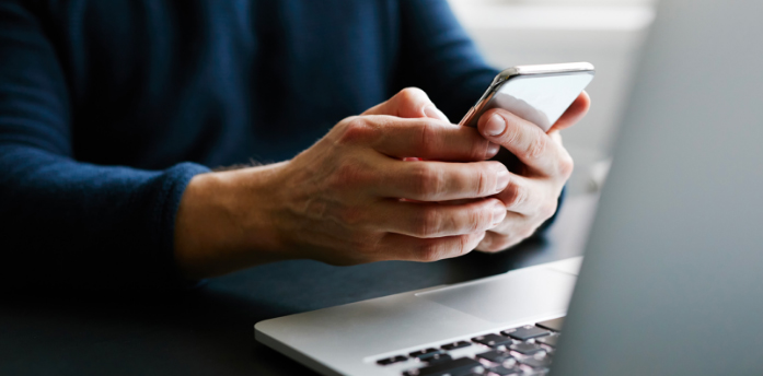 person mobile phone and laptop in office
