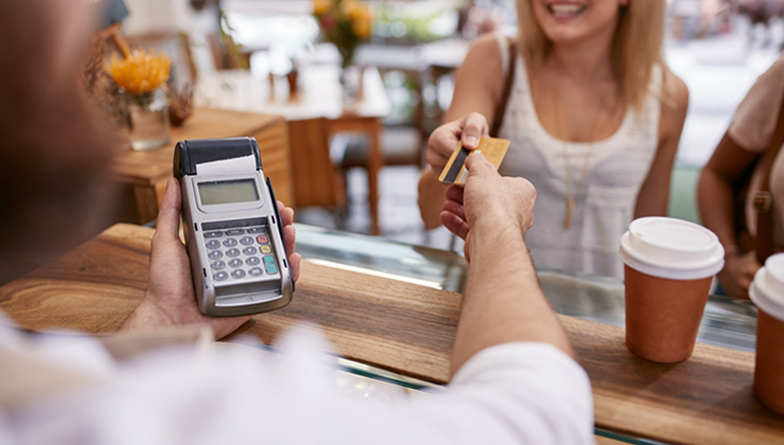 woman paying with a credit card in a coffee shop