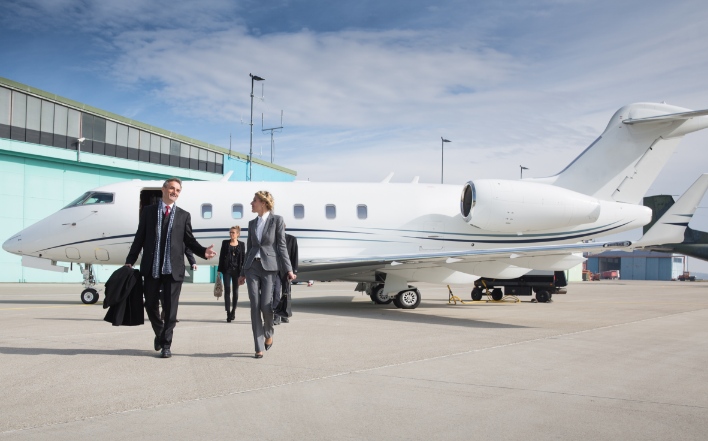 Professionals walking down the runway after disembarking from a private jet